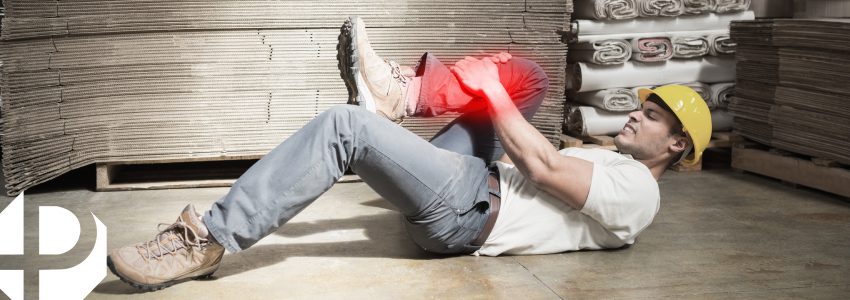 Accidente de trabajo, persona en el suelo con dolor en la rodilla